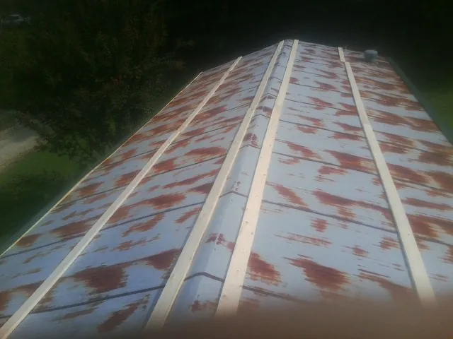 Rusted metal roof panels with new wood purlins before replacement — Storm Damage Roof Repair in Grayling by Roofing Brothers